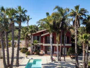 a house with palm trees in front of it at Villa Nunziatina in Carlentini