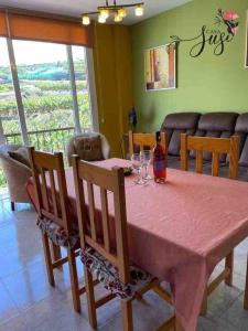 a dining room table with a bottle and glasses on it at Casa Susi in Tazacorte