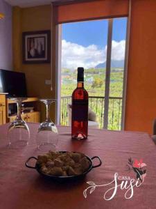 a bottle of wine and a plate of food on a table at Casa Susi in Tazacorte +5 photos