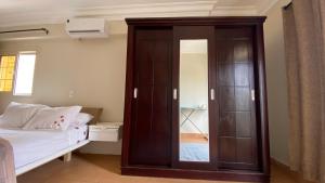a bedroom with a large wooden cabinet next to a bed at Comfortable 3BR New Cairo Prime Spot in Cairo