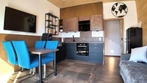 a kitchen with a table and blue chairs in a room at Apartment in Reutte, Austria in Pflach