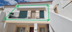 a building with two green arrows on the side of it at FM Central Vila Apartment in Carvoeiro
