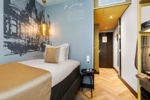 a room with a bed and a wall with a picture at Hotel Die Port van Cleve in Amsterdam