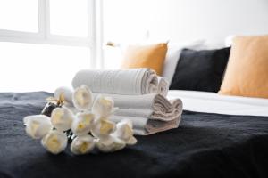 einen Haufen Handtücher und Blumen auf dem Bett in der Unterkunft GuestReady - Ria Reflection Studios in Aveiro