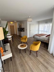 a room with a bed and two yellow chairs at Résidence Services Seniors DOMITYS - Villa Ulma in Lille