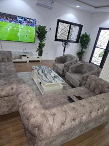 a living room with a large couch and a tv at Camara's Home in Sali Nianiaral +8 photos