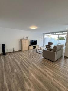 an empty living room with a couch and a television at Bungalow Noa in Calpe