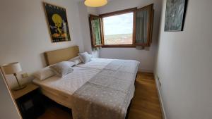 ein kleines Schlafzimmer mit einem Bett mit Fenster in der Unterkunft Las Casitas de Bernuy VUT in Segovia