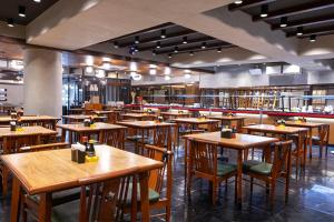 an empty restaurant with wooden tables and chairs at Nikkey Palace Hotel in São Paulo