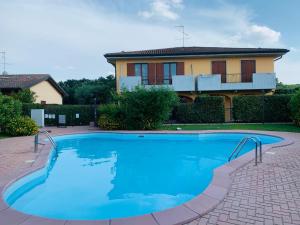 a large blue swimming pool in front of a house at Casa Bacher Pool&GardenPrivate&2,5kilometri to Peschiera del Garda center in Peschiera del Garda