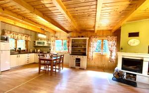 a large kitchen with a table and a fireplace at Amalka Wita in Sulęczyno