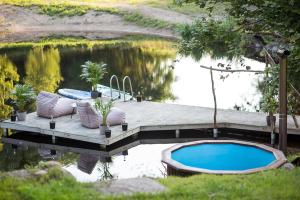 un quai avec une piscine à côté d'un plan d'eau dans l'établissement Shanti Resort - Retreat & Wellness Center, à Sarboriškės I 39 autres photos