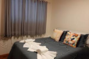 a room with black and white furniture and a curtain at Apto com sacada e vista vale dos vinhedos in Bento Gonçalves