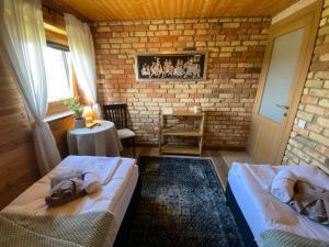 une chambre avec deux lits et un mur de briques dans l'établissement Shanti Resort - Retreat & Wellness Center, à Sarboriškės I