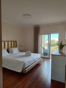 a bedroom with a large white bed and a balcony at O Pomar in Cabanas by Wave Algarve in Cabanas de Tavira