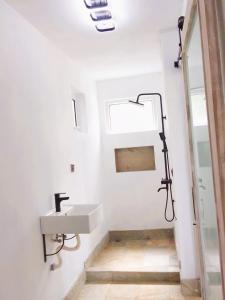 a white bathroom with a sink and a shower at Mountain Lodge in La Laura