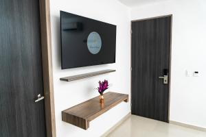 a room with a tv and a door with a vase of flowers at Hotel Brisas in Tierra Bomba