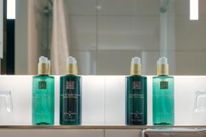 a row of four shampoo bottles sitting on a shelf at Hotel Die Port van Cleve in Amsterdam