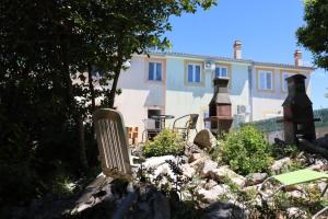 a yard with chairs and a house in the background at Holiday Home Desire in Kras