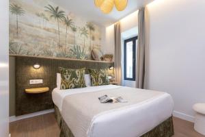 a bedroom with a large bed with a painting on the wall at Genteel Home Gamazo in Seville +37 photos