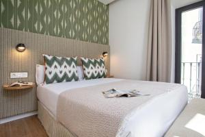a hotel room with a bed with two certificates on it at Genteel Home Gamazo in Seville
