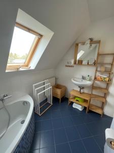 a bathroom with a bath tub and a sink at Ferienhaus Jastoria in Sassnitz +37 photos
