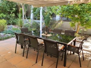 a dining table and chairs on a patio at Wild Olive Guest House & Villa in Cape Town