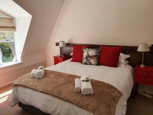 a bedroom with a bed with towels on it at Wild Olive Guest House & Villa in Cape Town