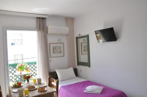 a room with a bed and a table and a window at Helen Suites in Limín Khersonísou