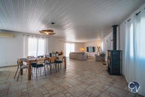 a dining room and living room with a table and chairs at Villa et appartement à Goudargues in Goudargues