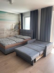 a bedroom with two beds and a painting on the wall at Apartament Pogodny in Chojnice