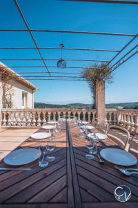 a table with chairs and wine glasses on a deck at Villa et appartement à Goudargues in Goudargues