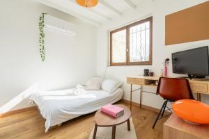 モントルイユにあるVotre écrin méditerranéen aux portes de Parisのベッド、机、テレビのある寝室
