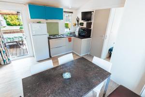 Kuchyňa alebo kuchynka v ubytovaní Bungalow 3 chambres pour 6 pers avec Climatisation Camping 3 etoiles