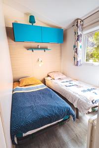 Posteľ alebo postele v izbe v ubytovaní Bungalow 3 chambres pour 6 pers avec Climatisation Camping 3 etoiles