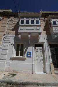 a white building with a blue sign on it at Bonaci Boutique Hotel in Sliema