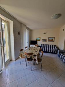 a living room with a table and chairs and a couch at Villa Sante Residence in Pesaro
