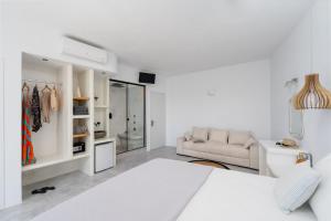 a white room with a bed and a couch at Manios Suites in Agia Anna Naxos