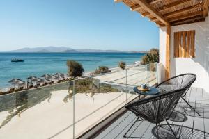 a balcony with a table and chairs on the beach at Manios Suites in Agia Anna Naxos