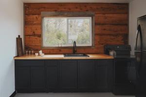 a kitchen with a sink and a window at Secluded rustic 2-bedroom cabin on nature retreat in Miramonte +7 photos