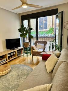 a living room with a couch and a tv at Moderno apartamento en el corazón de Zaragoza con posibilidad de 2 garajes in Zaragoza