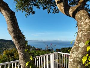 a view of the ocean from between two trees at Arirang Sea View Homestay in Senggigi 