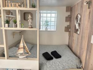two pictures of a room with a bed and a toy boat at Idéal couple ! Le Nid du Bourg - Proche plage et commerces - serviettes de toilette & linge de lit compris in Ouistreham