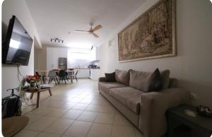 a living room with a couch and a flat screen tv at Home4U apt1, just 8Km from airport in Markopoulo