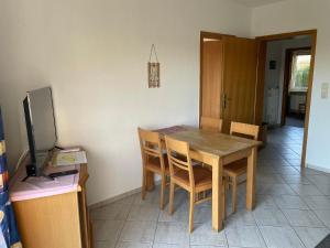 海利根港Gepflegte Erdgeschossferienwohnung in Heiligenhafen的厨房配有桌椅和电视。