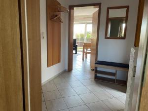 海利根港Gepflegte Erdgeschossferienwohnung in Heiligenhafen的走廊里有一个房间，里面有一面镜子和一台电视 更多4张照片