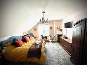 a bedroom with a large bed with colorful pillows at Rosebank House Bed & Breakfast in Strathyre