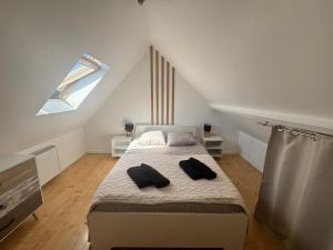 a bedroom with a bed with two pillows on it at Cosy Duplex ! Situation centrale - proche plage et commerces - linge de lit et serviettes de toilette compris in Ouistreham