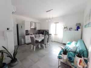 a kitchen and living room with a table and chairs at Casa Antonella, a due passi dalla spiaggia, Total relax in Solanas