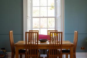a dining room table with three chairs and a window at Starbright Cottage in Peebles +16 photos